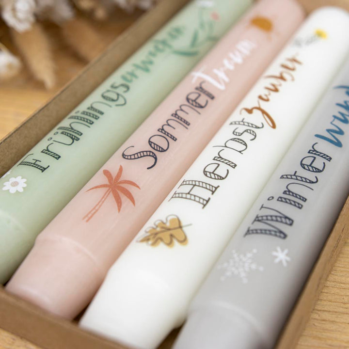 Bunte Stabkerzen mit Jahreszeiten-Motiven für Frühling, Sommer, Herbst und Winter