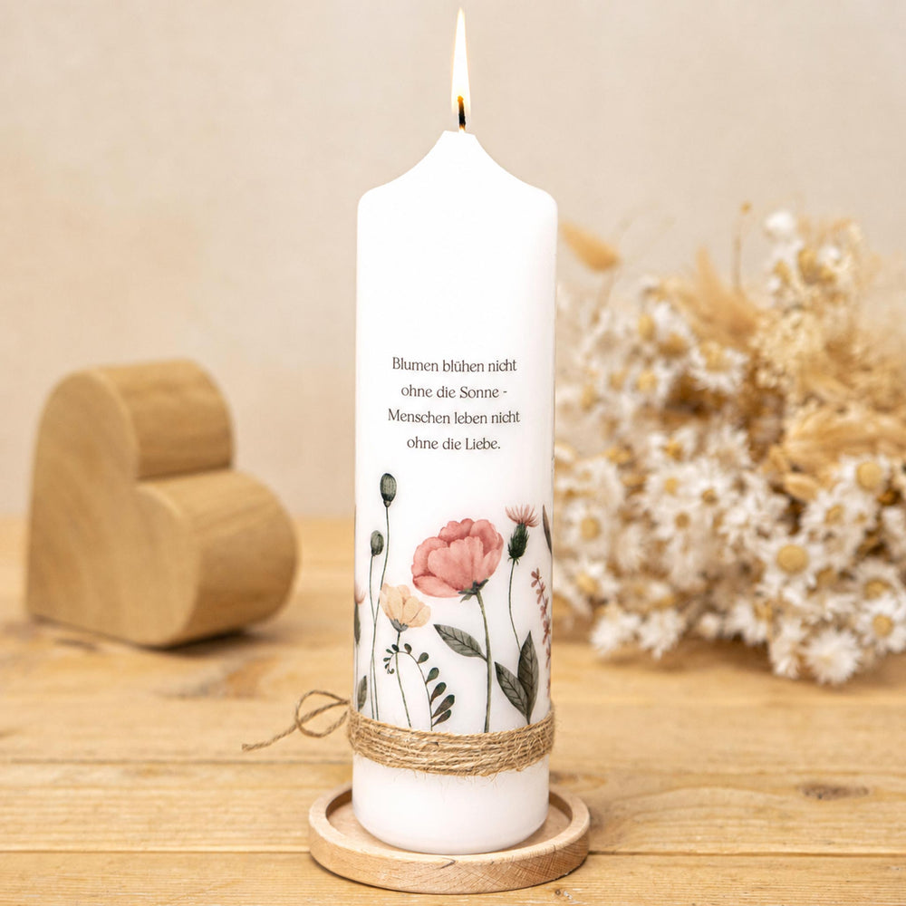Hochzeitskerze mit Wildblumen und frei wählbarem Trauspruch auf einem Holz-Kerzenteller, dahinter Trockenblumen als Deko