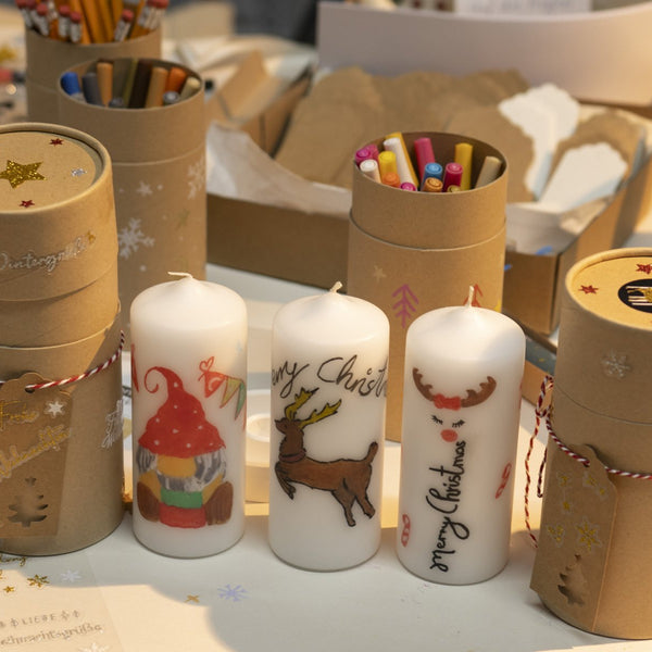 Weihnachtskerzen mit Wichtel- und Rentiermotiv am Adventsmarkt 2025