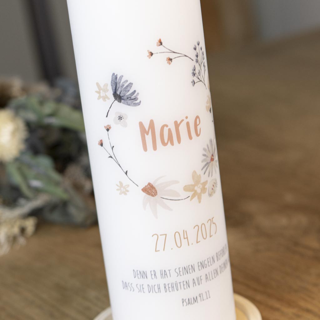 Zarte Wildblumen im Kranz auf der Kommunionkerze