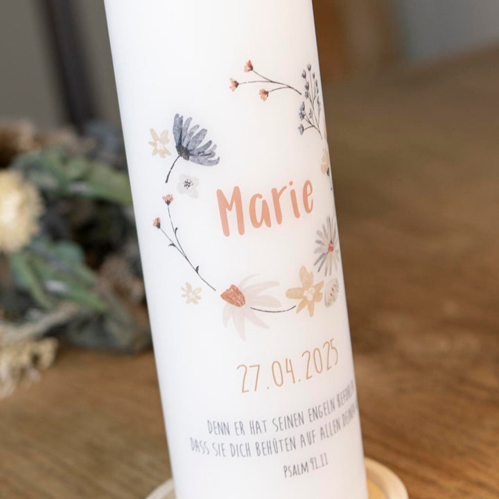 Zarte Wildblumen im Kranz auf der Kommunionkerze
