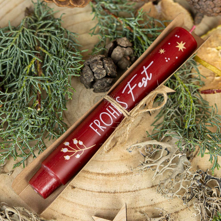 Rote Stabkerze Frohes Fest, weihnachtlich verpackt als Geschenk