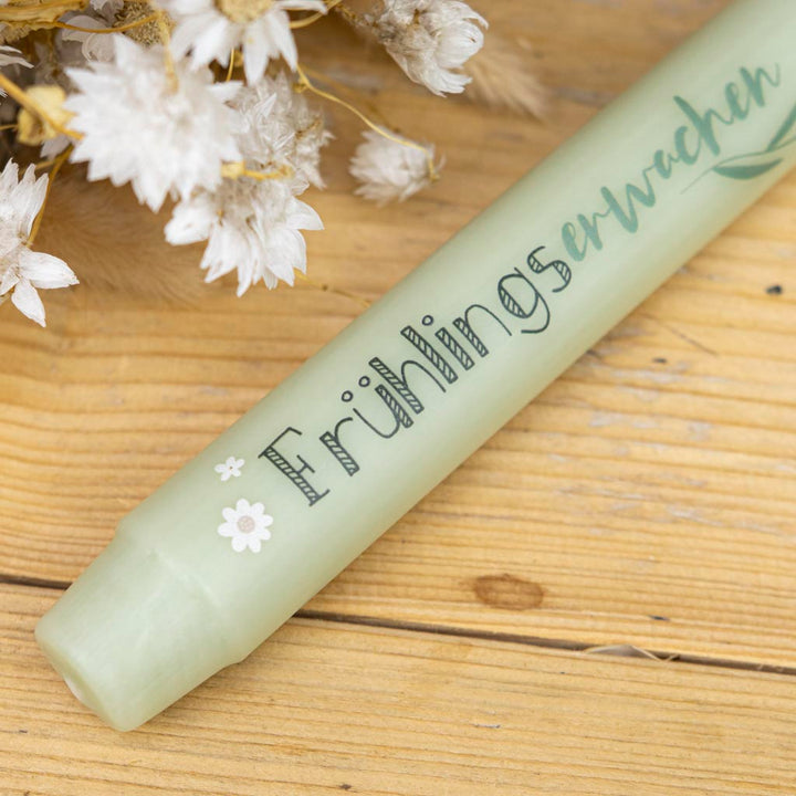 Salbeigrüne Stabkerze mit Blumen als Frühlingsdeko