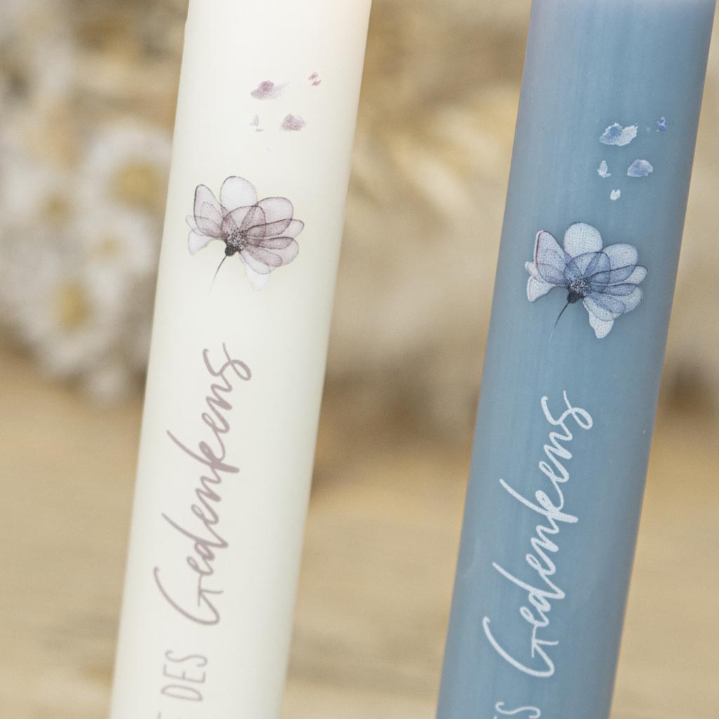 Gedenkkerze mit Blumenmotiv und verwehten Blueten