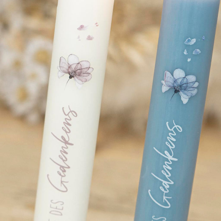 Gedenkkerze mit Blumenmotiv und verwehten Blueten