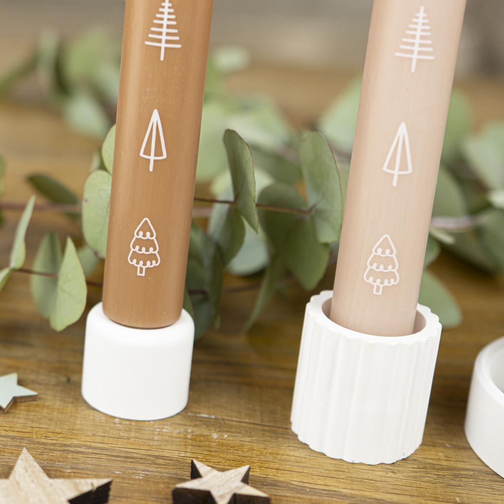 Weihnachtliche Stabkerze mit Tannenbäumen, dekoriert mit Stabkerzenhaltern