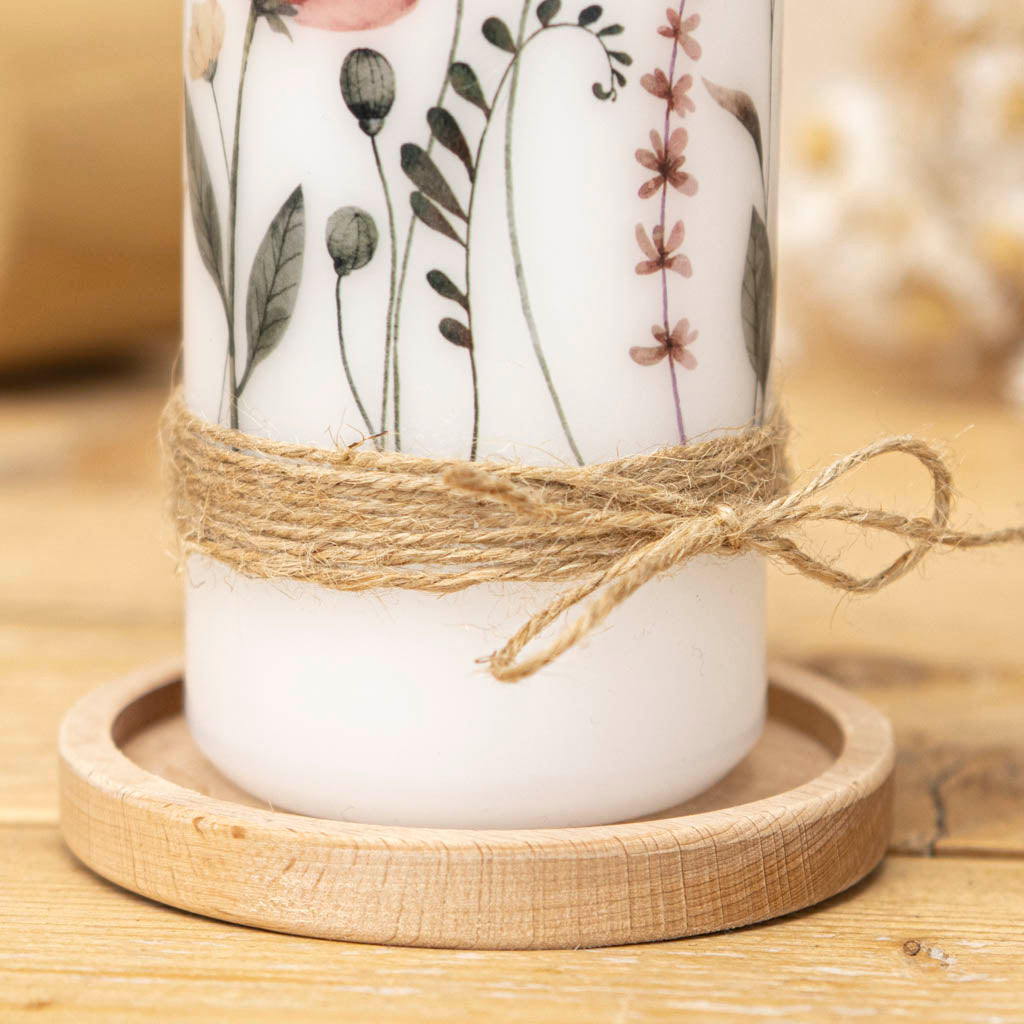 Wiesenblumen-Motiv und Juteband der Taufkerze in Altrosa im Detail