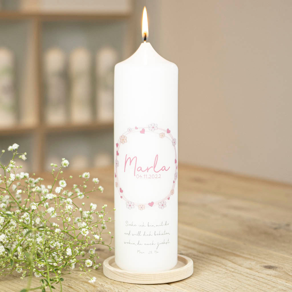 Personalisierte Taufkerze Marla in Rosa mit Blütenkranz auf einem Kerzenhalter aus Holz