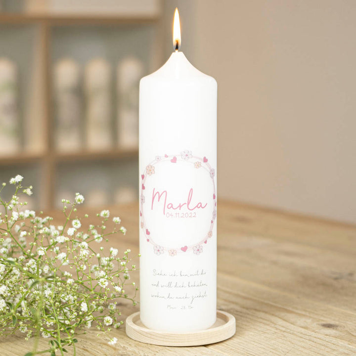 Personalisierte Taufkerze Marla in Rosa mit Blütenkranz auf einem Kerzenhalter aus Holz