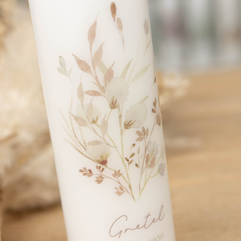 Gedenkkerze mit Wildblumen und Klee als Hoffnungssymbol