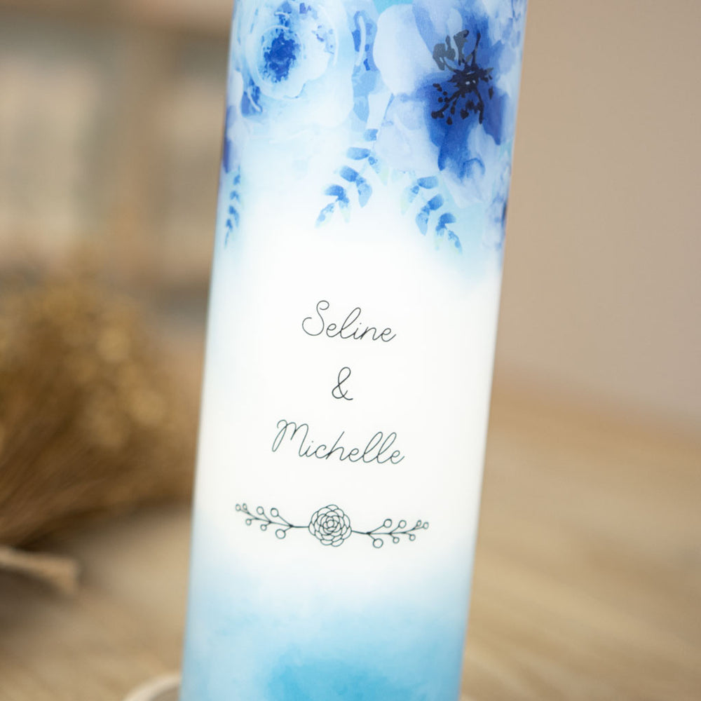Blaue Aquarell-Blüten der Hochzeitskerze um die Namen