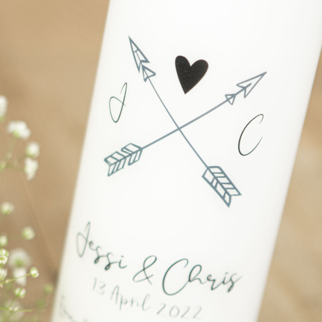 Zwei gekreuzte Pfeile und kleines Herz auf der Hochzeitskerze
