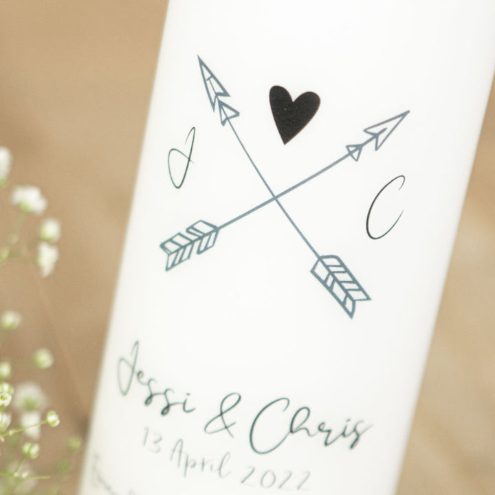 Zwei gekreuzte Pfeile und kleines Herz auf der Hochzeitskerze