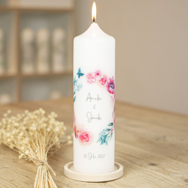 Hochzeitskerze Schmetterling mit Namen und Datum, daneben Kerzenhalter aus Holz