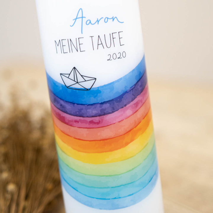 Detailaufnahme des Aquarell-Regenbogens mit Papierboot auf der Taufkerze